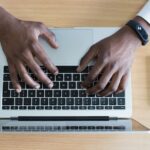 Hands typing on a laptop's keyboard.